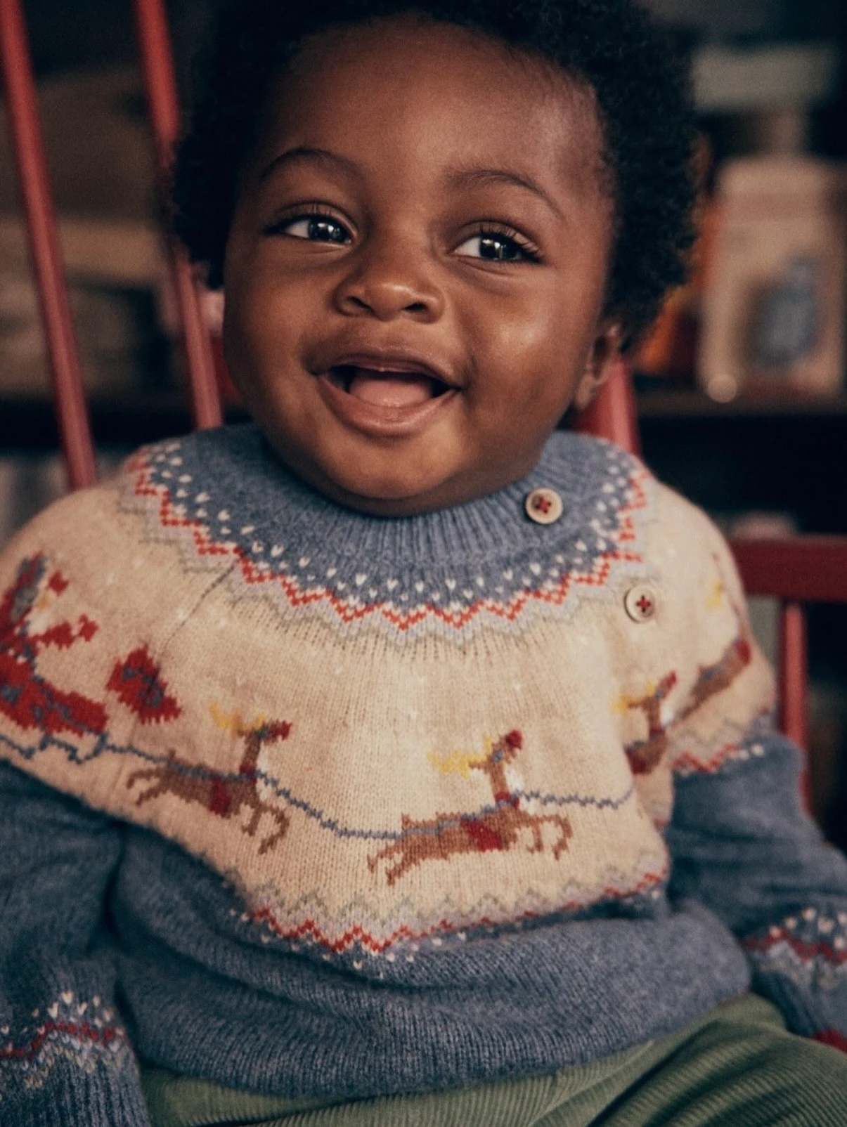Smiling baby in a reindeer Fair Isle jumper, Mini Boden Polar Post Winter 2026